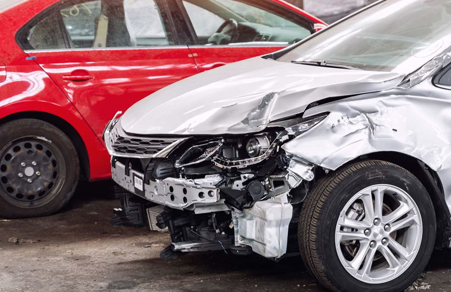 auto grigia con telaio danneggiato e nello sfondo macchina rossa